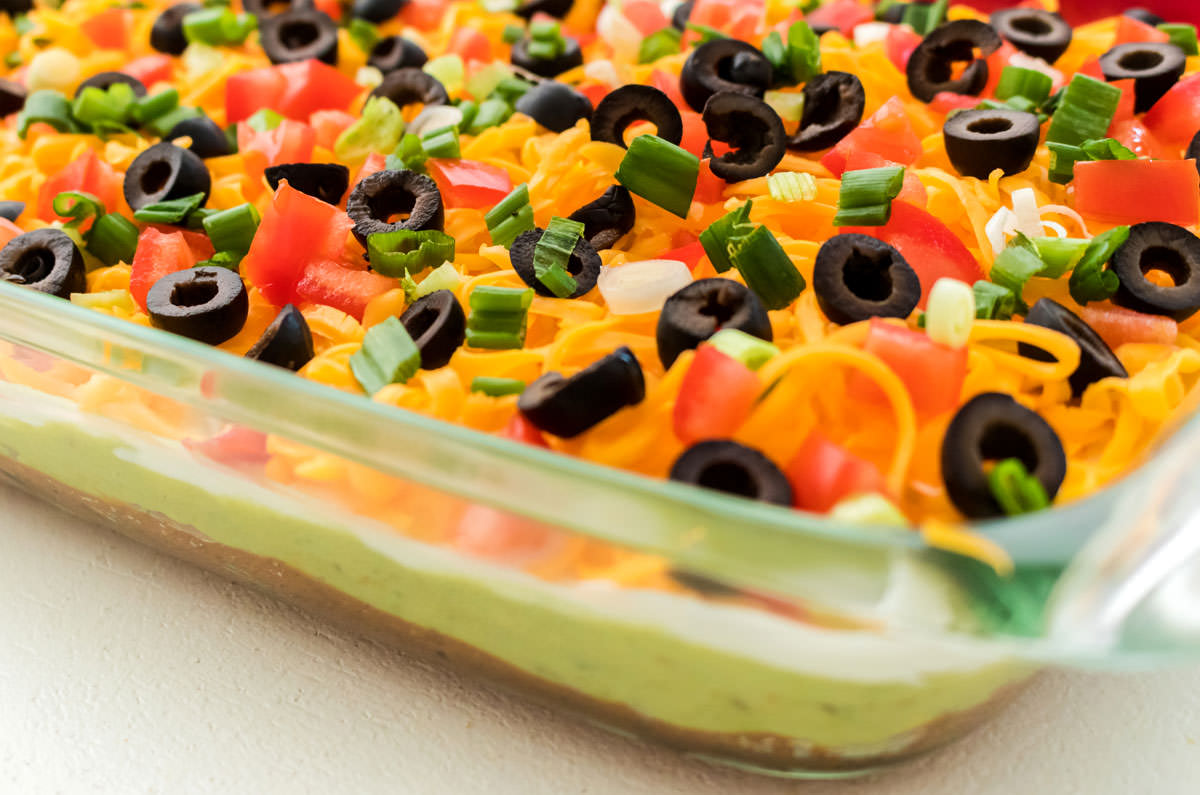 Closeup on a glass baking dish filled with 7 Layer Dip.
