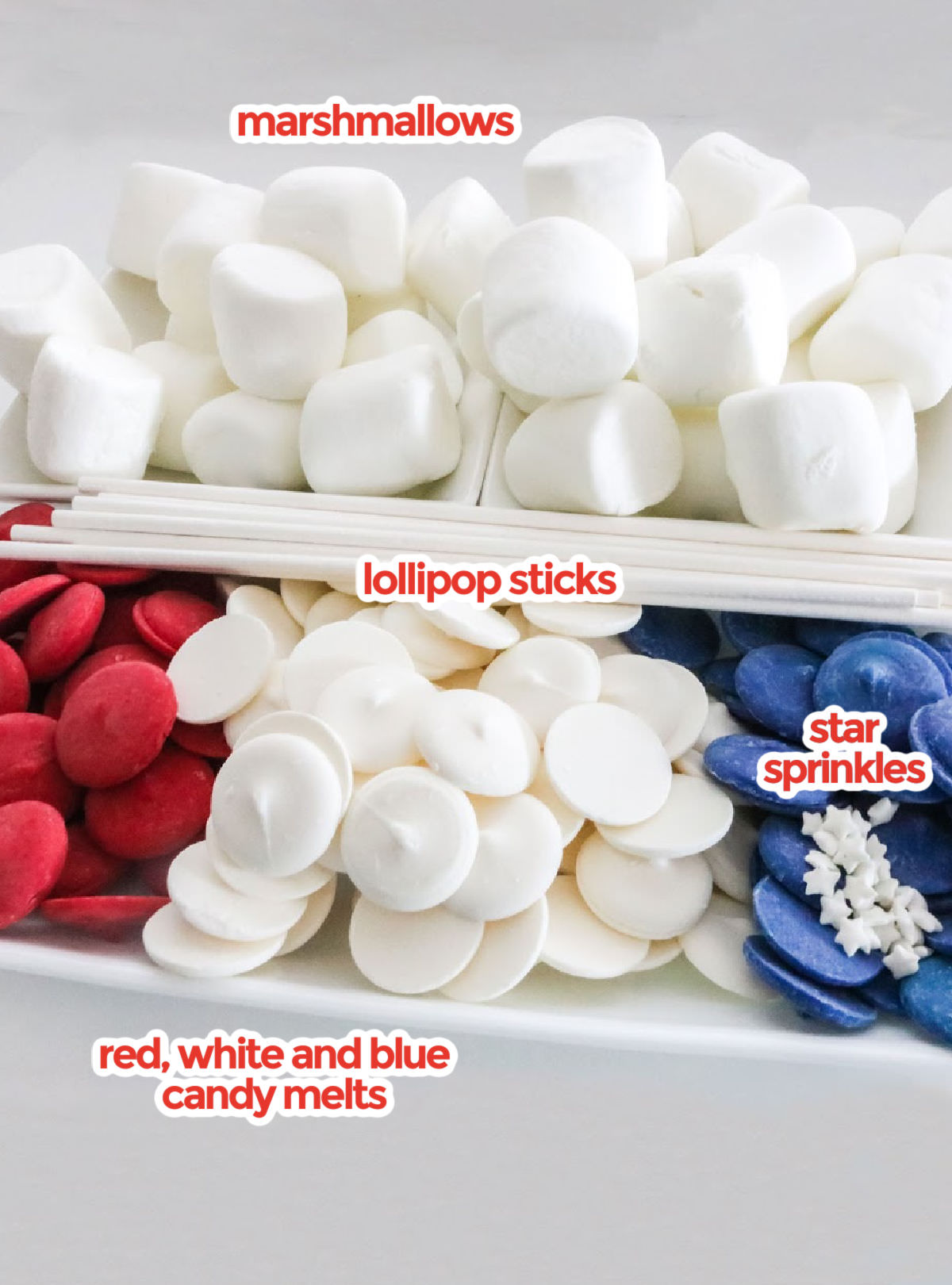 All the ingredients you will need to make American Flag Marshmallow Pops including marshmallows, lollipop sticks, and red, white and blue candy melts.