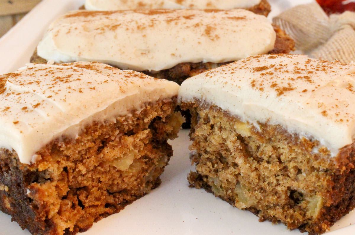 Closeup on a batch of Apple Bread Mini Loaves frosted with Cream Cheese Frosting and dusted with Cinnamon.