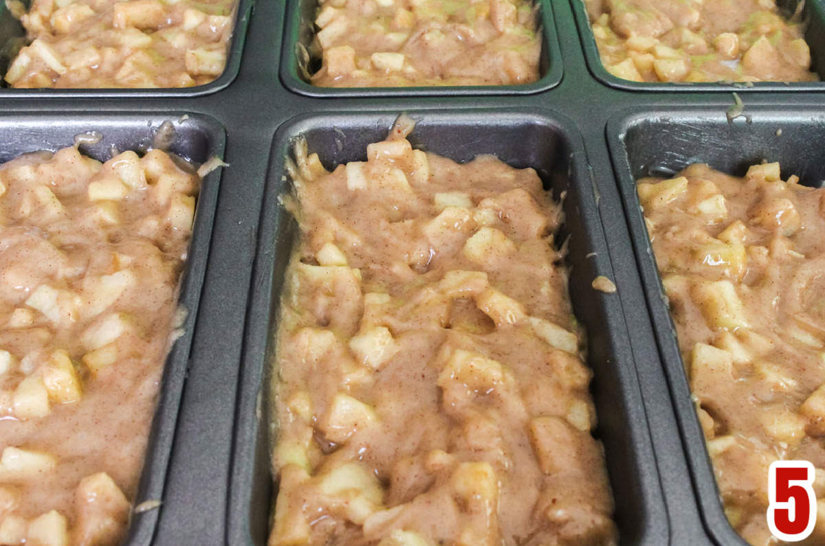 Closeup on a mini loaf pan filled with Apple Bread batter ready to go in the oven.