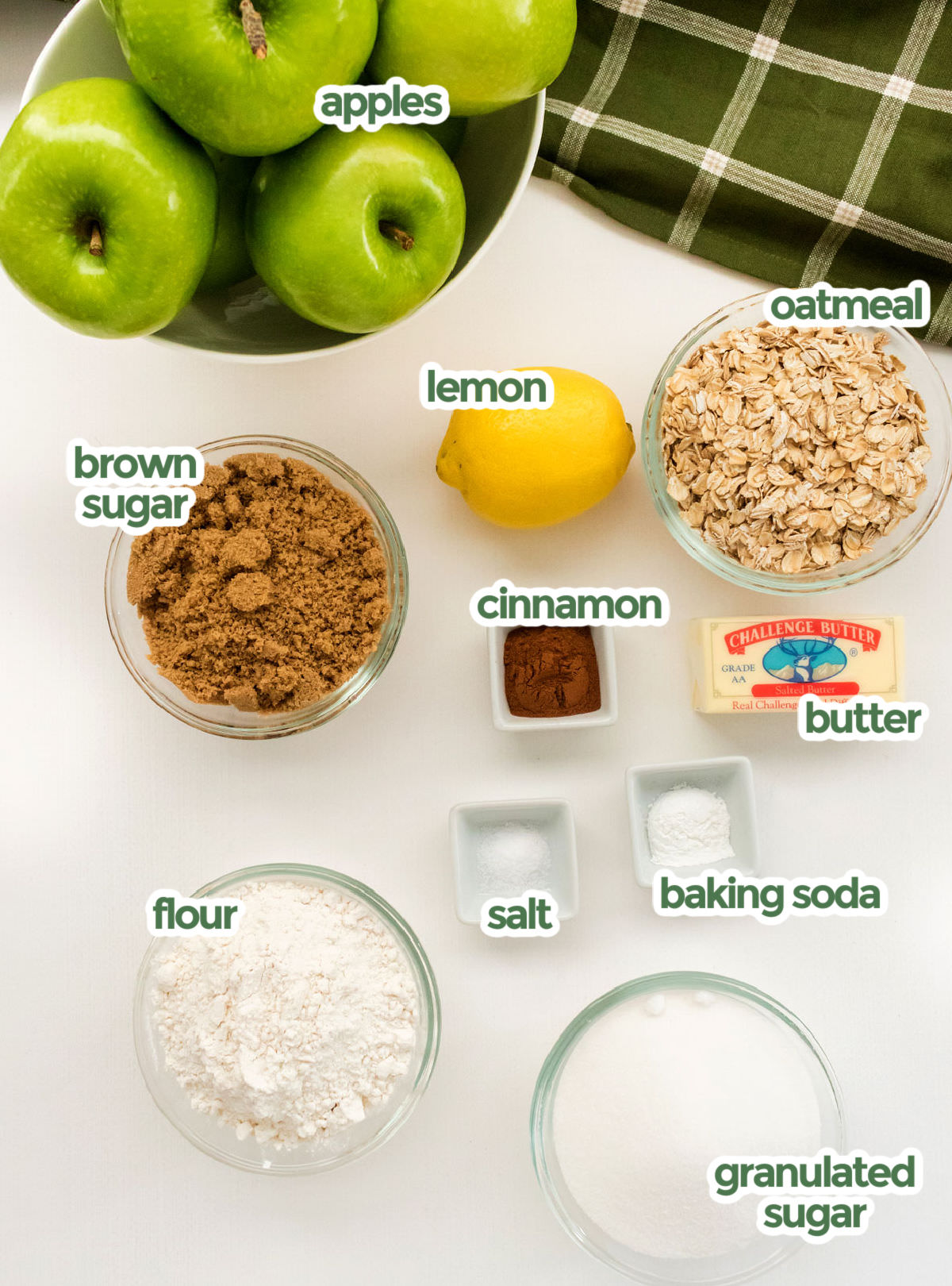 All the ingredients you will need to make Apple Crisp including apples, oatmeal, lemon, brown sugar, cinnamon, butter, baking soda, salt, flour and granulated sugar.