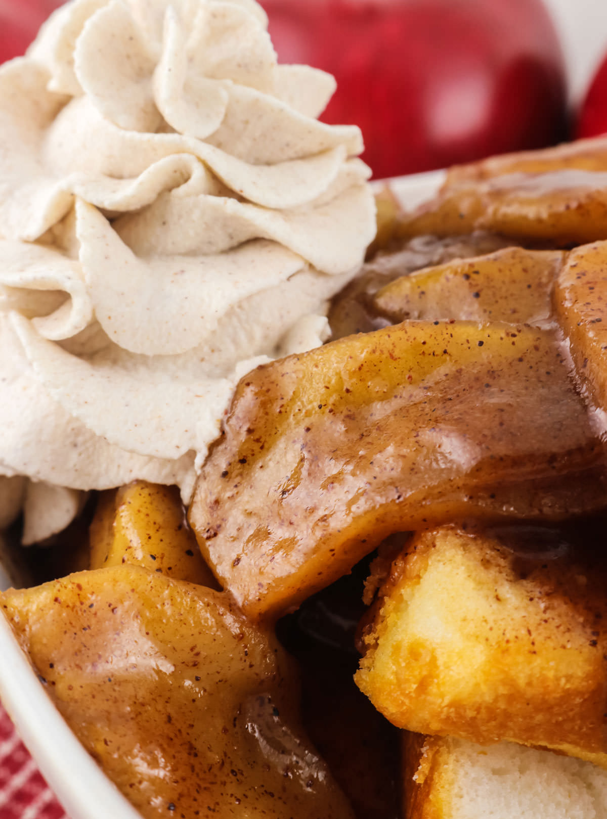 Closeup on a white bowl filled with angel food cake, Baked Apples and Cinnamon Whipped Cream.