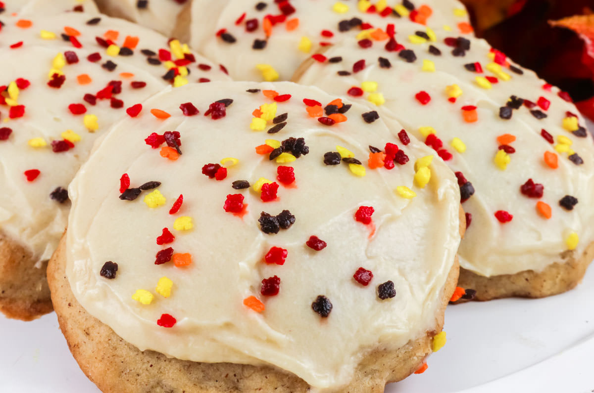 Closeup on a six Banana Spice Cookies with Brown Sugar Cream Cheese Frosting sitting on a white serving platter.