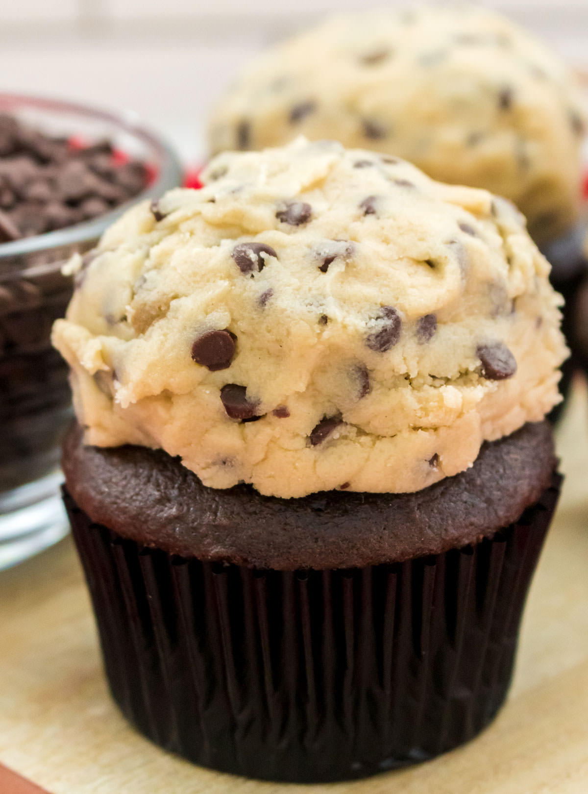 Closeup on a chocolate cupcake topped with a dollop of The Best Cookie Dough Frosting.