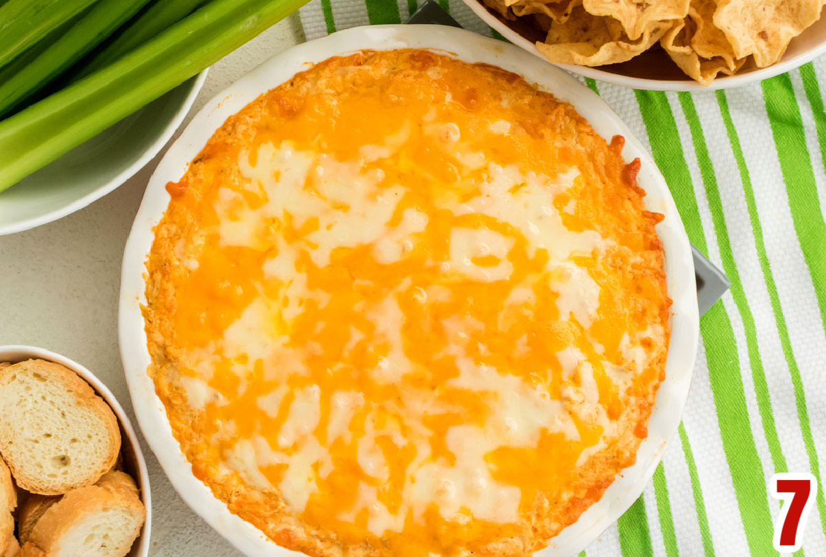 Overhead shot of a white ceramic dish holding the Buffalo Chicken Dip covered in melted cheese.