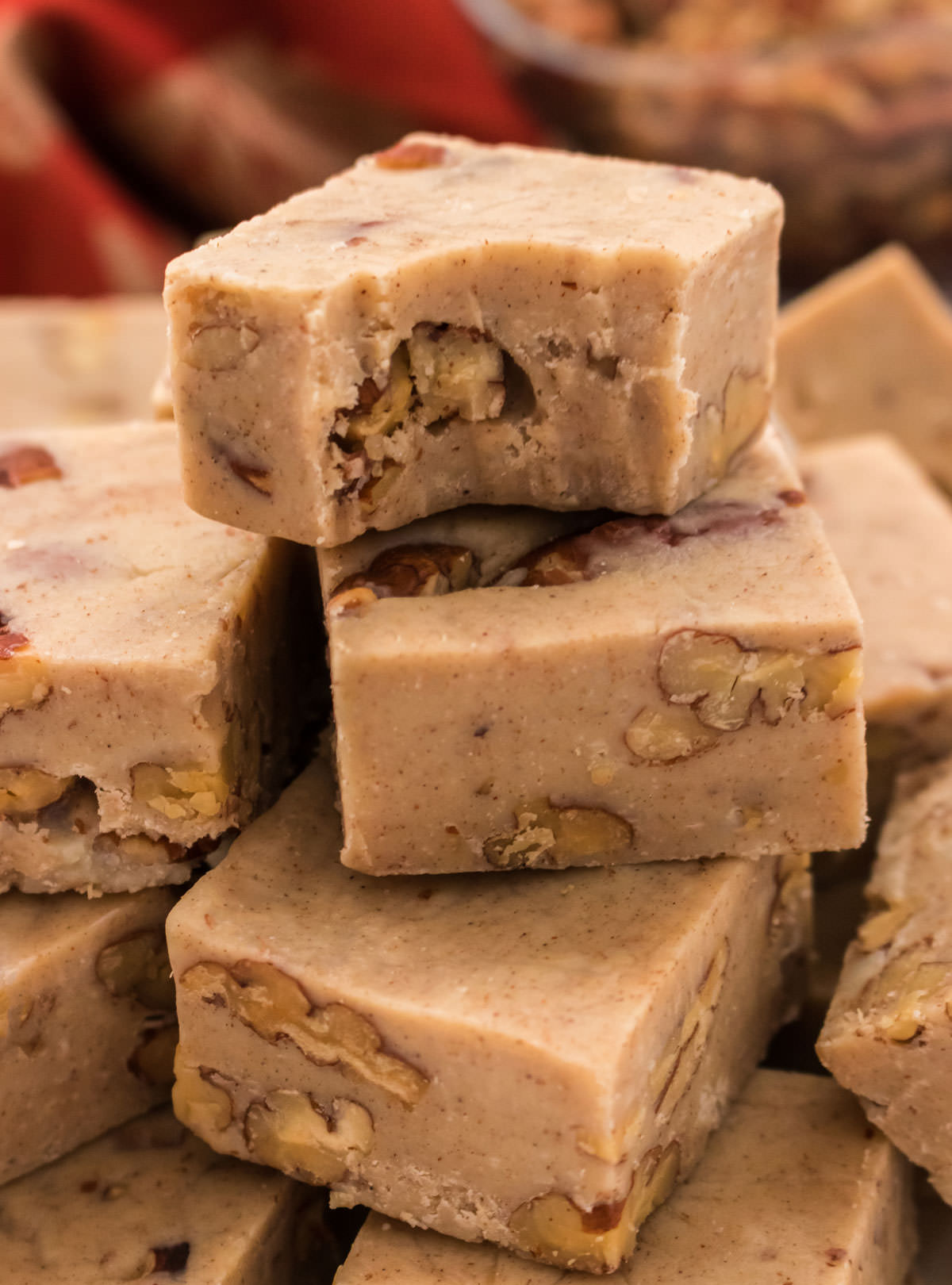 Closeup on a stack of Butter Pecan Fudge, the top piece with a bite taken out of it.