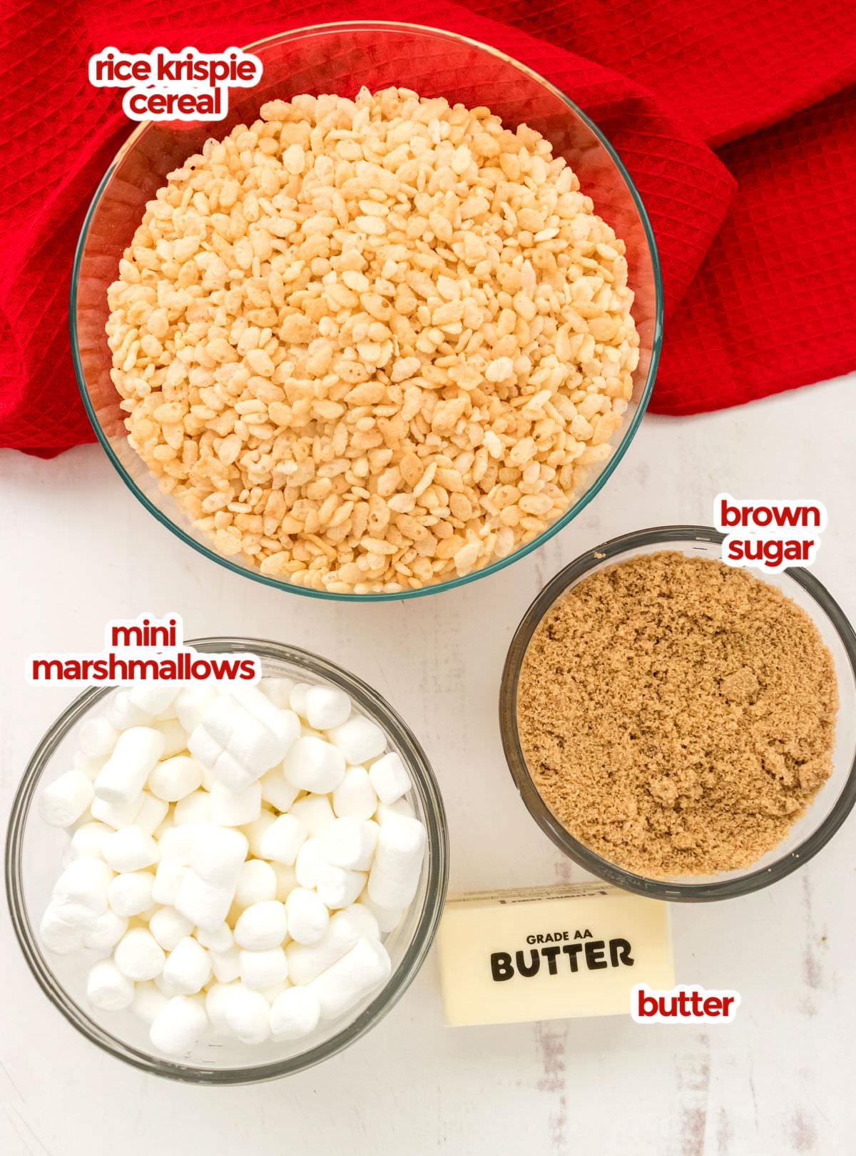 All the ingredients you will need to make Caramel Rice Krispie Treats including Rice Krispie Cereal, Brown Sugar, Mini Marshmallows and Butter.