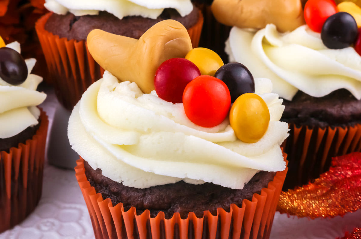 Closeup on the top of a Thanksgiving Cupcake decorated with a Cornucopia made out of candy.