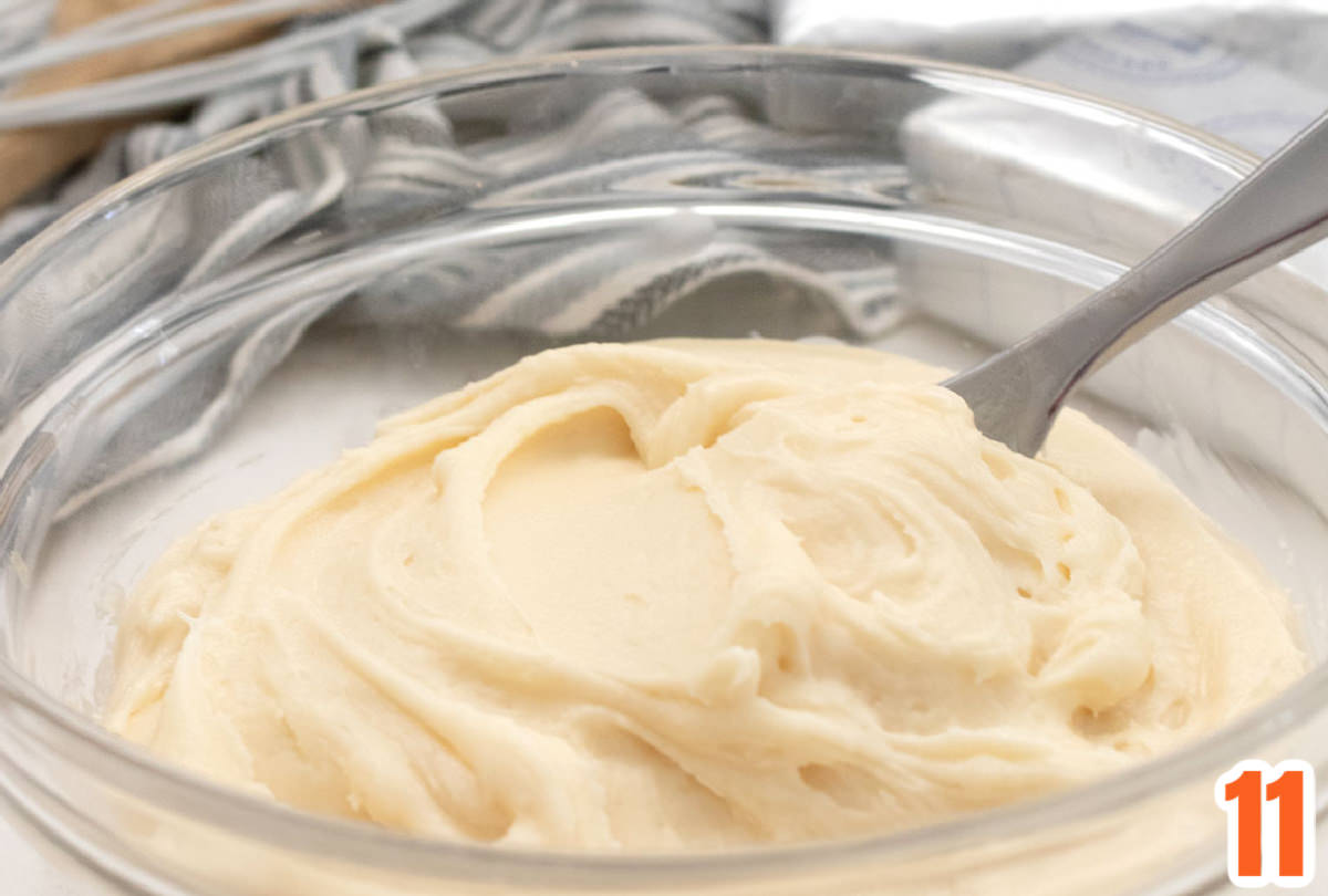 Closeup on a glass bowl filled with homemade Cream Cheese Frosting.