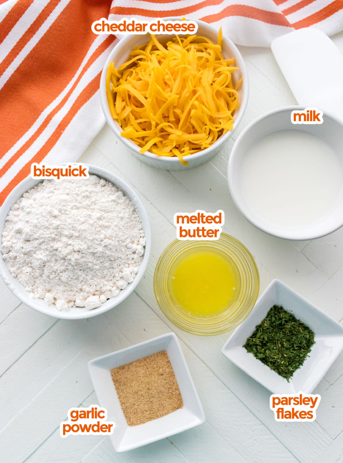 All the ingredients you will need to make Cheese Garlic Biscuits including  Bisquick, Cheddar Cheese, Milk, Melted Butter, Parsley Flakes and Garlic Powder.
