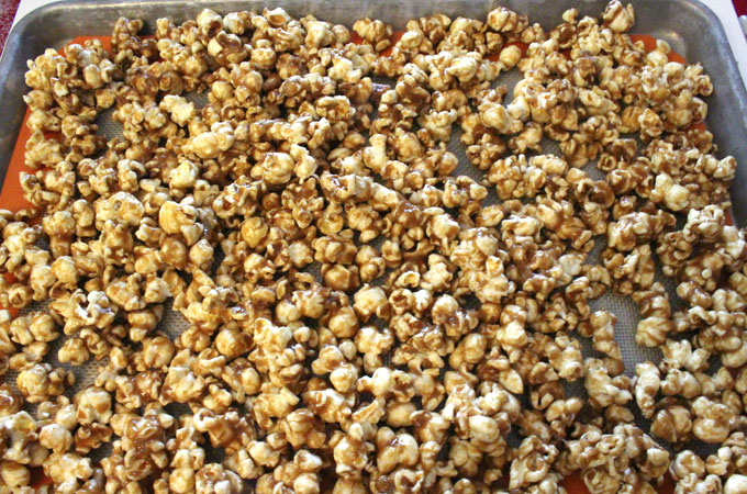 Pour caramel corn onto a cookie sheet