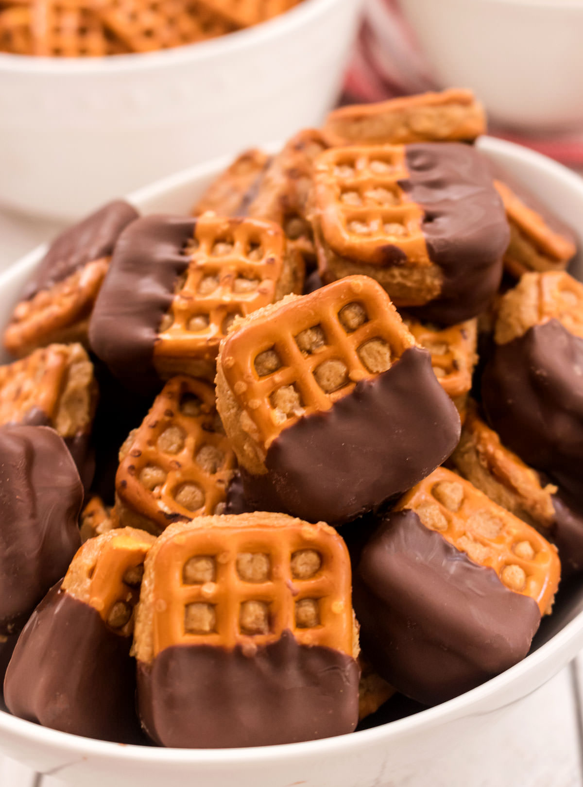 Closeup on a white serving bowl filled with Chocolate Peanut Butter Pretzel Bites.