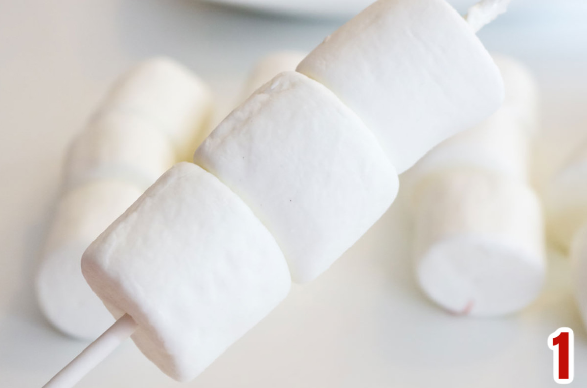Three marshmallows on a lollipop stick.