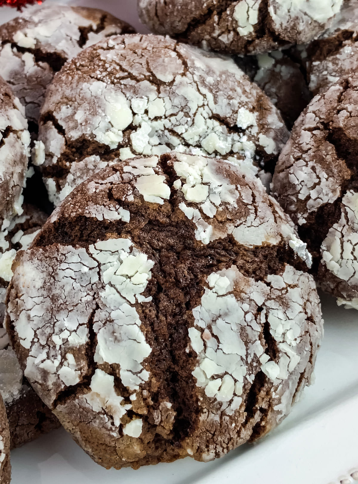 Closeup on a white serving plate filled with Chocolate Crinkle Cookies.