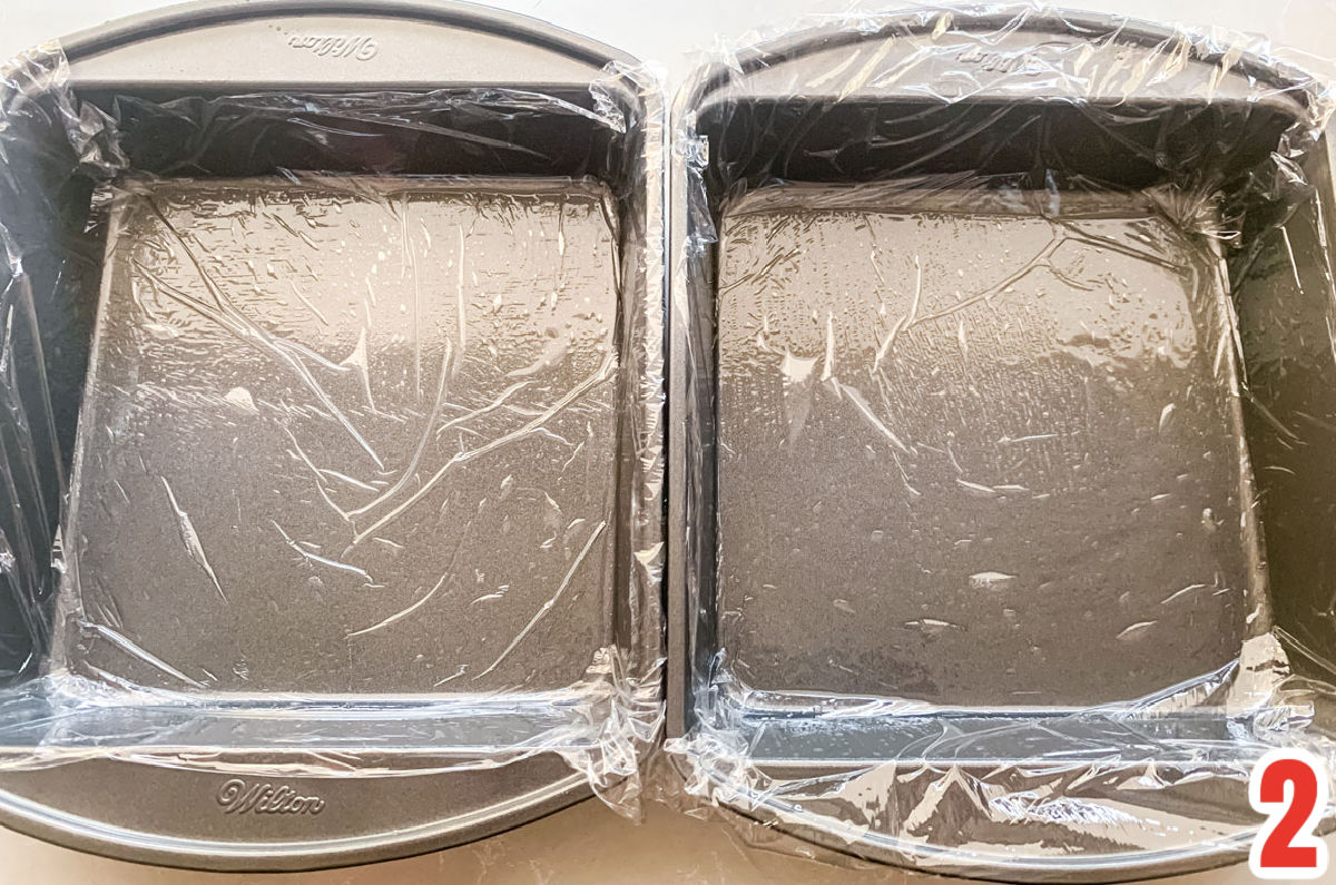Two 8x8" pans lined with plastic wrap.
