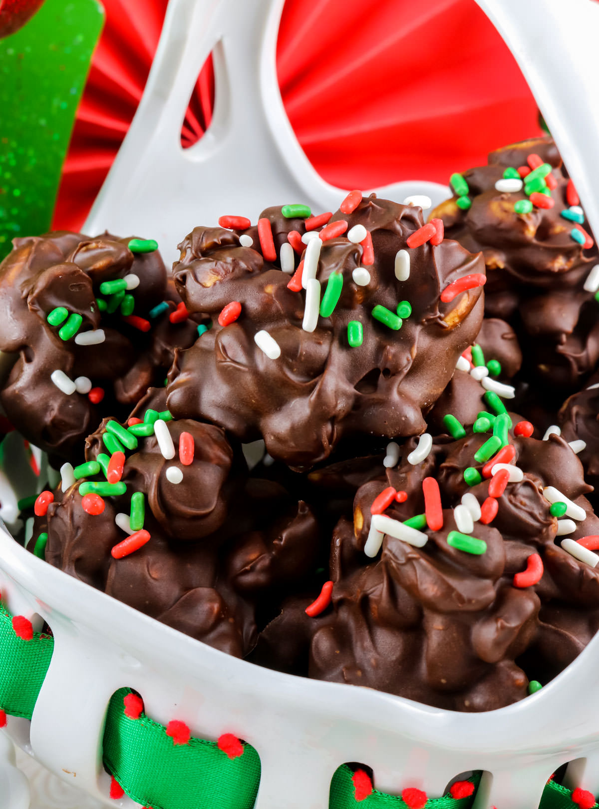 Closeup on a white serving bowl filled with Chocolate Peanut Clusters.