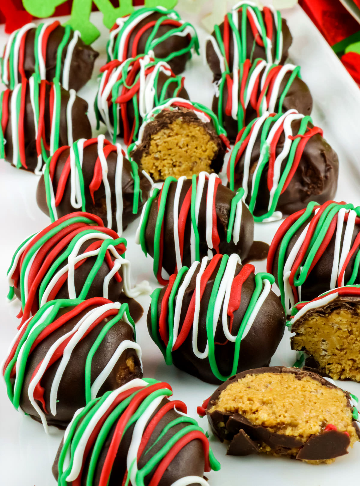 A batch of Christmas Peanut Butter Crunch Truffles sitting on a white serving platter.