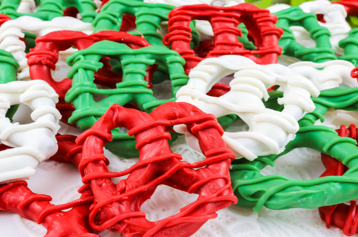 Closeup on a batch of Christmas Pretzels spread out on a white tablecloth.