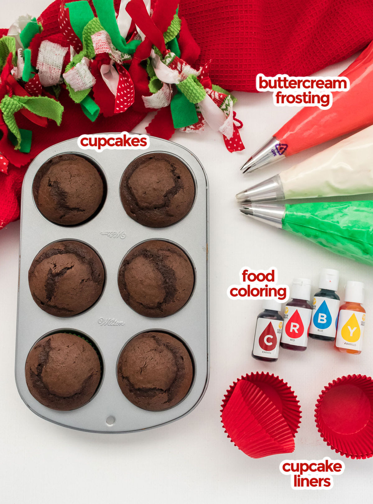 All the ingredients you will need to make Easy Christmas Cupcakes including cupcakes, buttercream frosting, food coloring and red cupcake liners.