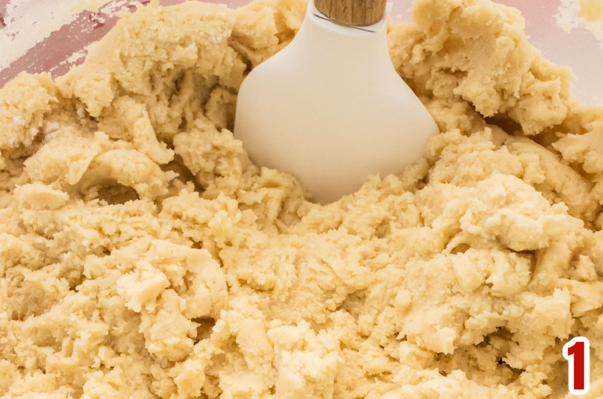 Closeup on a clear mixing bowl filled with Sugar Cookie dough.