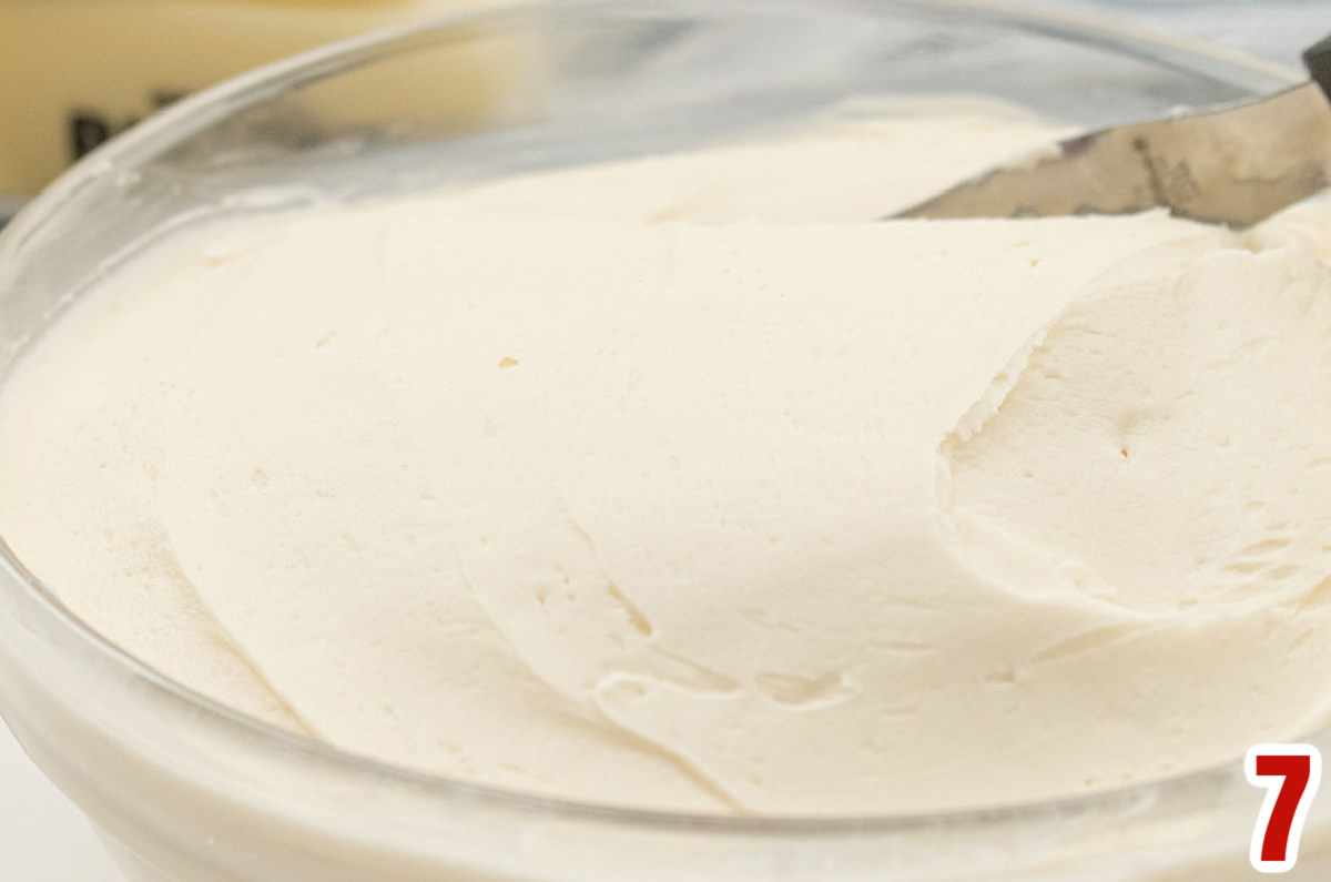 Closeup on a clear mixing bowl filled with homemade Buttercream Frosting.