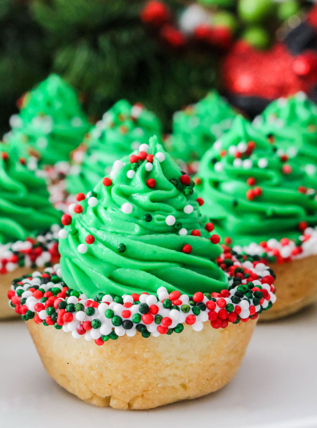 Closeup on a batch of Christmas Tree Cookie Cups sitting on a white table.
