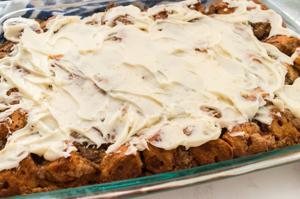 Close up of the Cream Cheese Frosting covering a pan of Cinnamon Roll Breakfast Casserole.