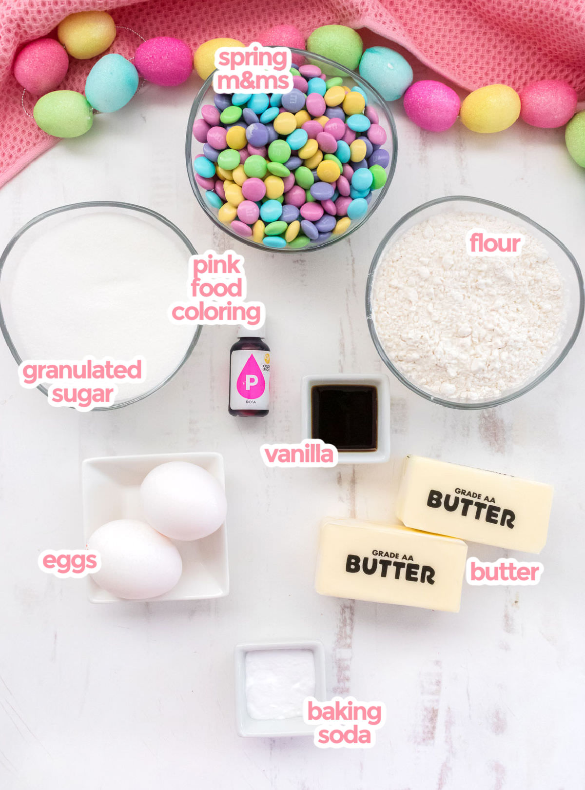 The ingredients you will need to make Easter M&M Sugar Cookies including  butter, sugar, eggs, vanilla, baking soda, flour, pink food coloring and Spring M&M's.