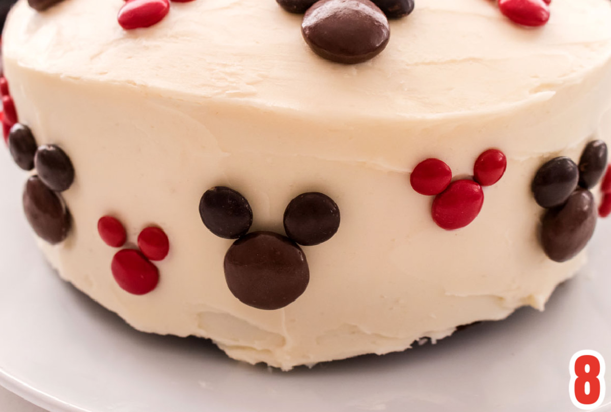 Closeup on the side of the Mickey Mouse Cake showing the brown and red Mickey Mouse heads made with M&M's.