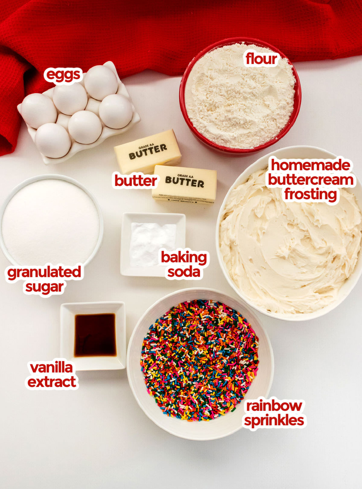 All the ingredients you will need to make Funfetti Sugar Cookie Bars including eggs, butter, flour, sugar, vanilla, baking soda, buttercream frosting and sprinkles.