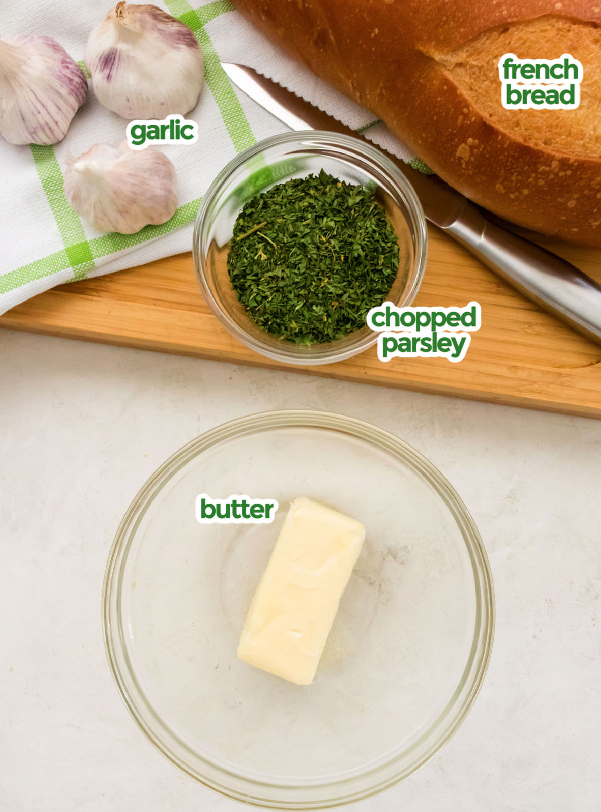 All the ingredients you will need to make Garlic Bread including French Bread, Chopped Parsley, Garlic and Butter.