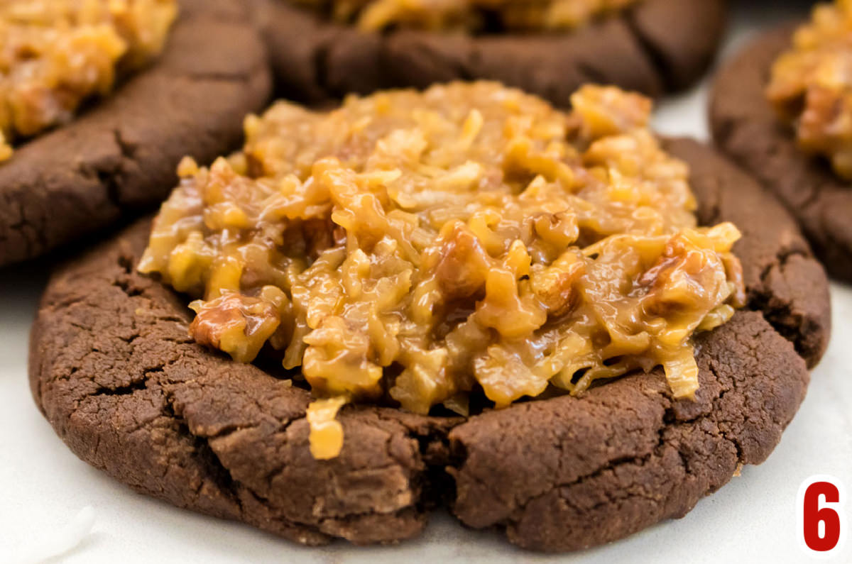 Closeup on a German Chocolate Cookie sitting on a white surface.