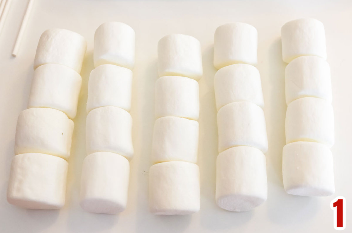 Five rows of marshmallows on a white table.