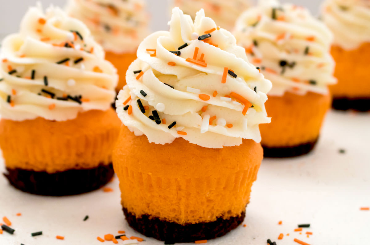 Closeup on six Brownie Cupcakes sitting on a white table surrounded by Halloween sprinkles.