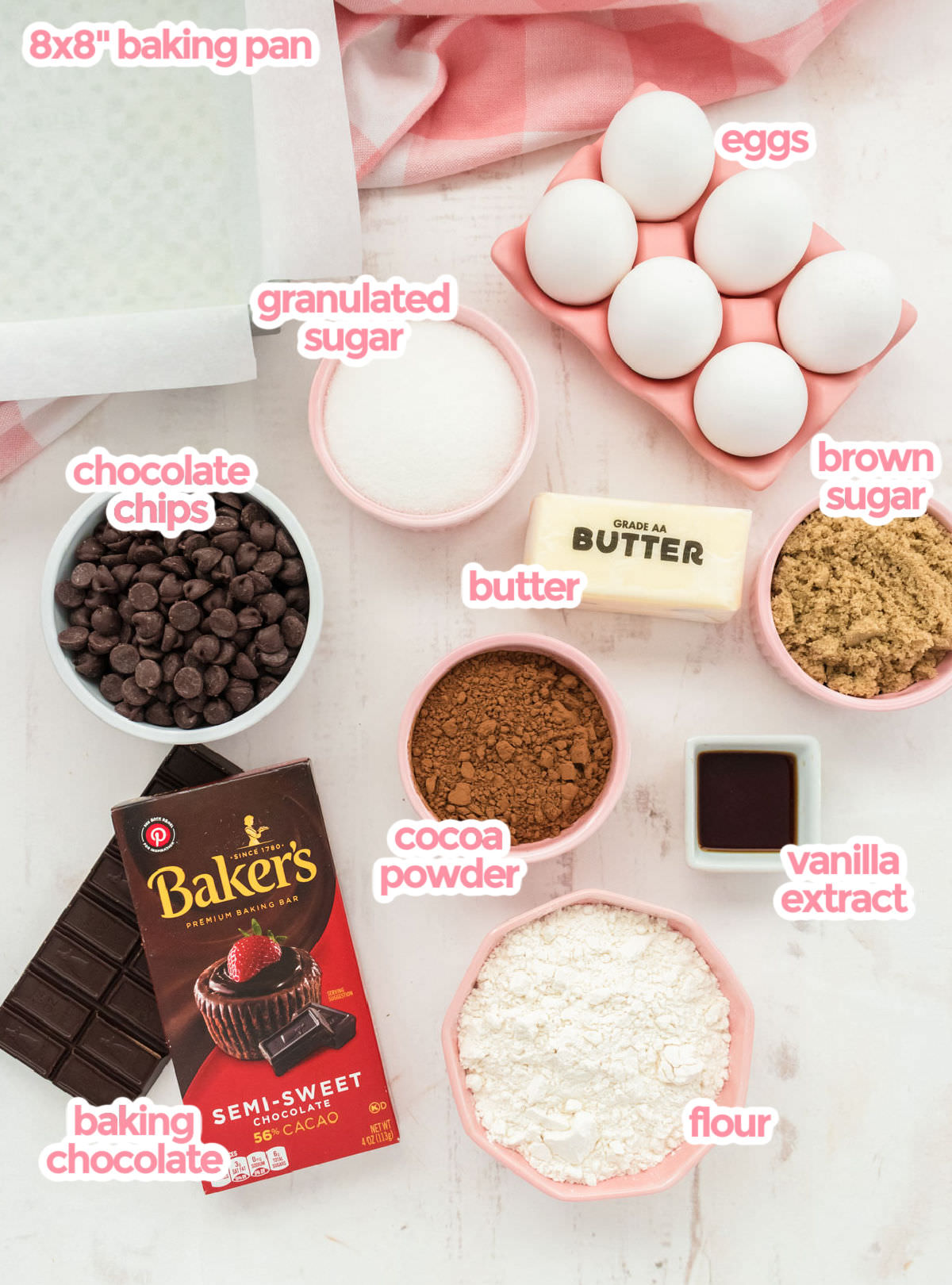 All the ingredients needed to make Homemade Fudge Brownies including eggs, sugar, chocolate bar, cocoa powder, chocolate chips, butter, vanilla and flour.