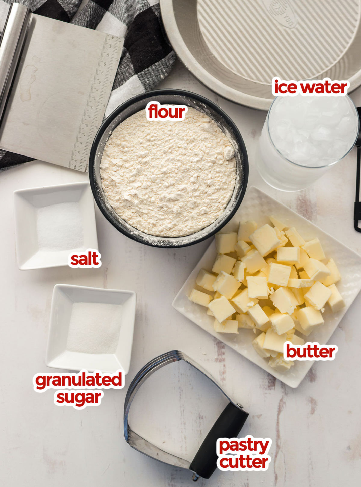 Ingredients needed to make a Homemade Pie Crust including flour, salt, sugar, butter and ice water.