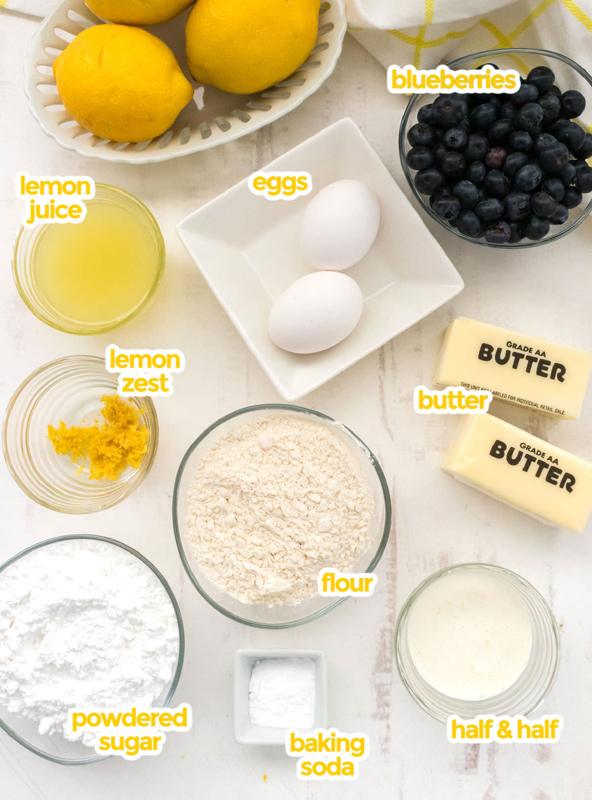 All the ingredients you will need to make Lemon Blueberry Cookies including butter, powdered sugar, eggs, lemon juice, lemon zest, Half & Half, Flour, Baking Soda and Fresh Blueberries.