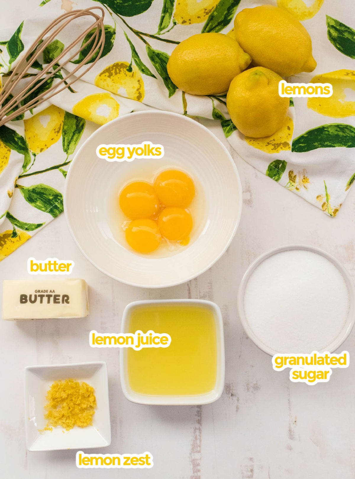 All the ingredients you will need to make our Easy Lemon Curd Recipe including lemons, egg yolks, butter, lemon juice, lemon zest and sugar.