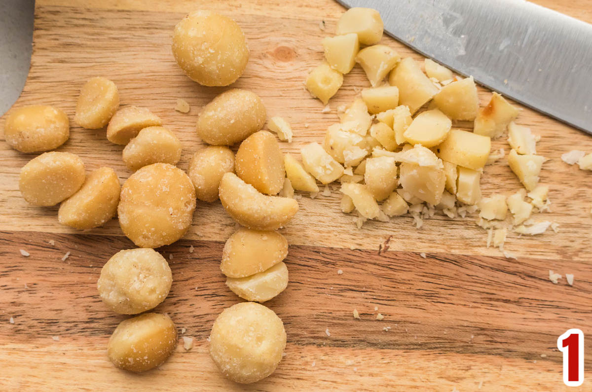 Macadamia Nuts on a cutting board with a knife.