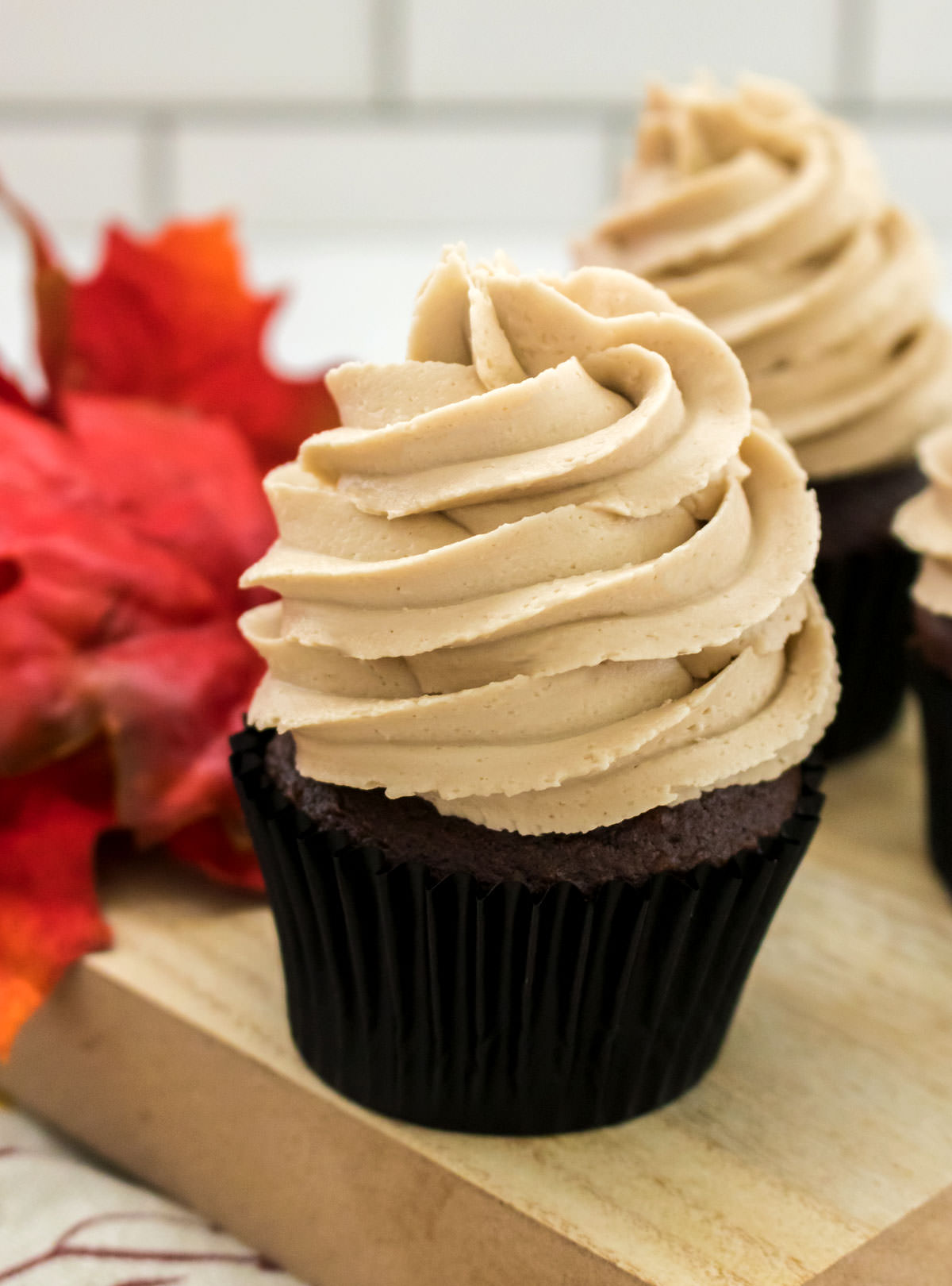 Closeup on a chocolate cupcake topped with The Best Maple Buttercream Frosting.