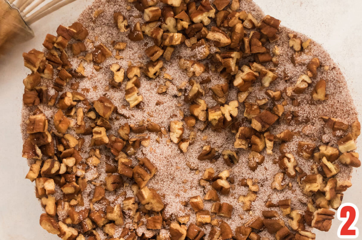 Closeup on a glass mixing bowl filled with Cinnamon, Sugar and chopped nuts.