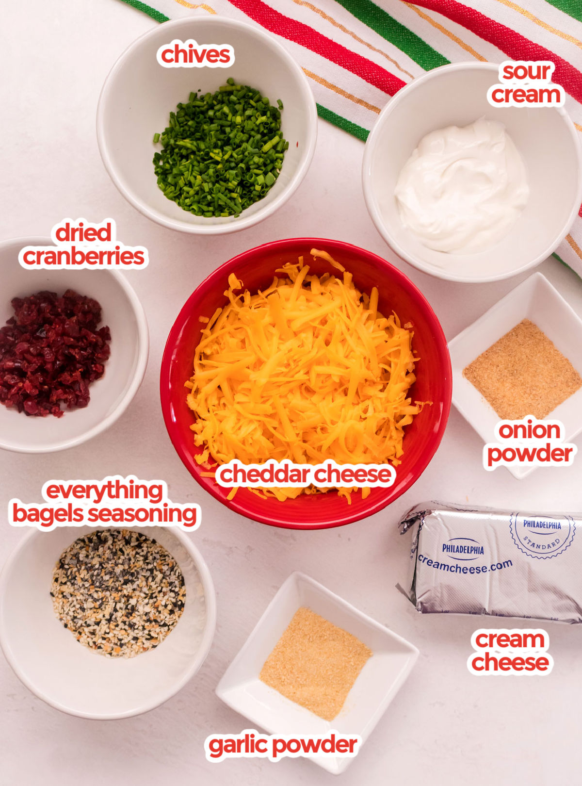 All the ingredients needed to make Cheese Ball Bites including sour cream, cream cheese, cheddar cheese, spices and toppings.