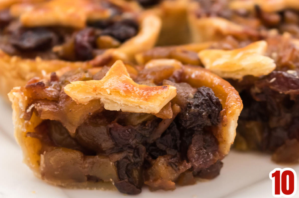 Closeup on a Mini Mincemeat Pie cut in half on a white dessert plate.