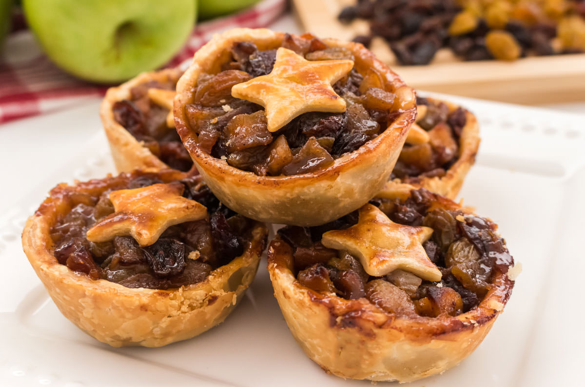 Closeup on a white dessert plate filled with five Mini Mince Pies.