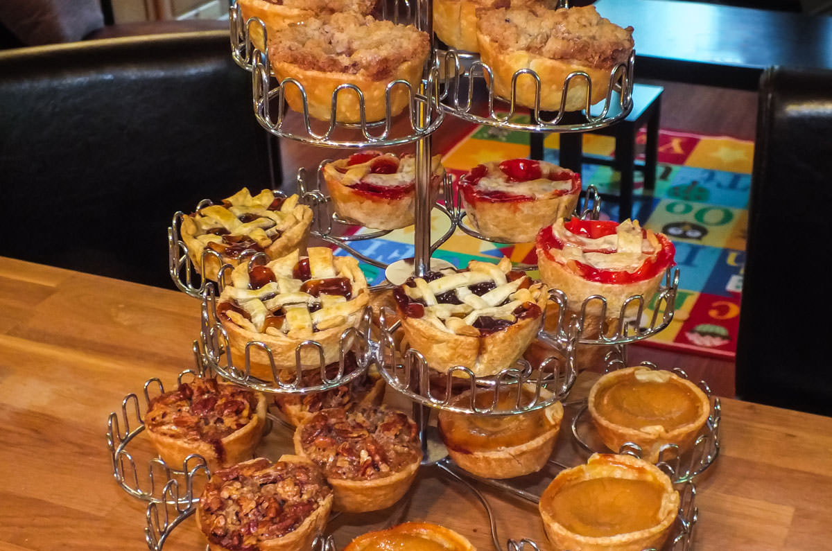 Closeup on a silver cupcake stand filled with Mini Pies for the Holidays in five different flavors.