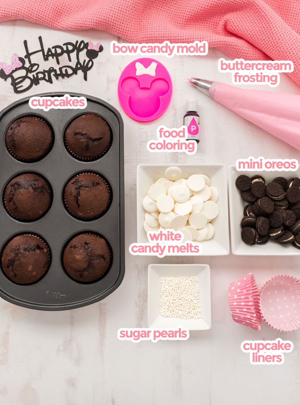 All the ingredients you will need to make Minnie Mouse Cupcakes including cupcakes, buttercream frosting, bow candy mold, white candy melts, mini oreos and sugar pearls.