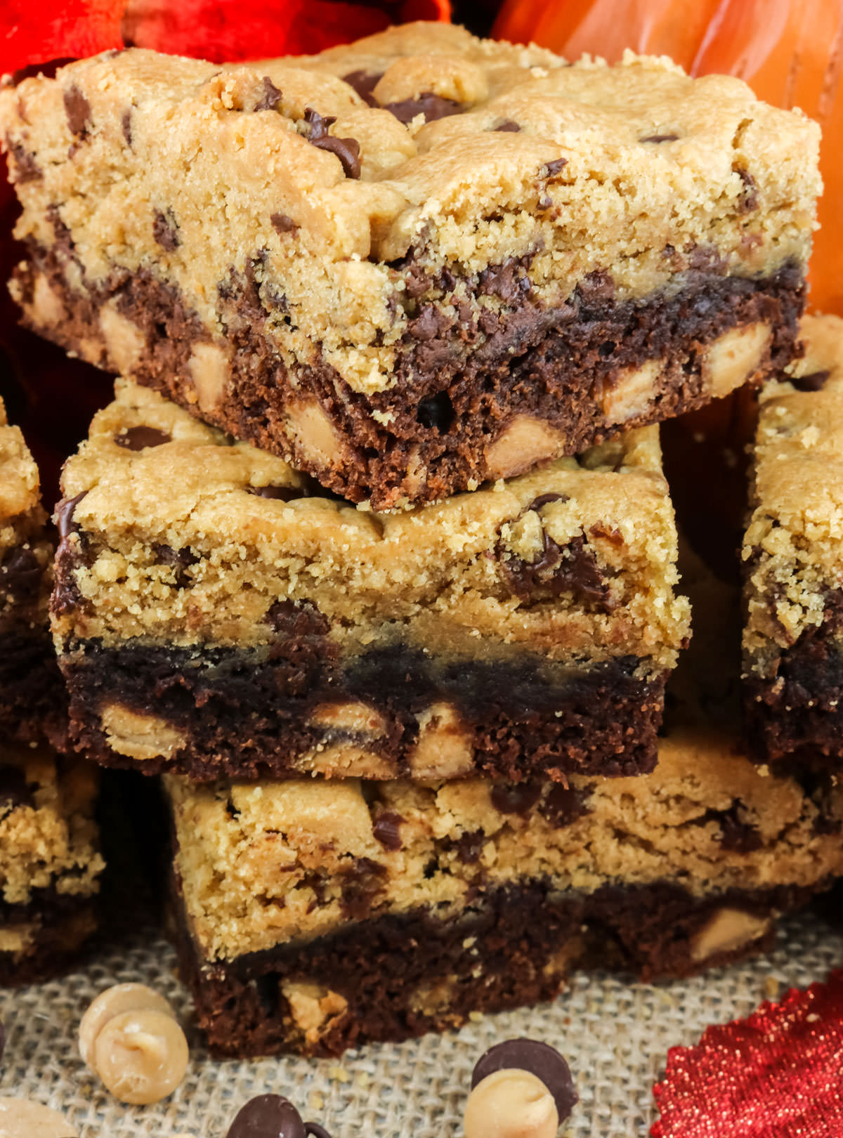 Closeup on a stack of three Peanut Butter Brookies sitting on a placemat surrounded by Peanut Butter Chips and Chocolate Chips.