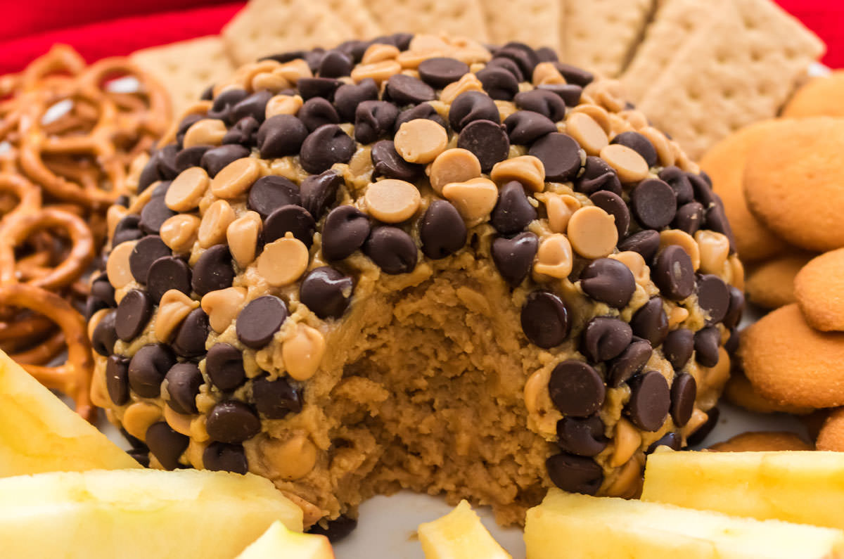 Peanut Butter Cheese Ball on a serving platter with a large bite take out of it.