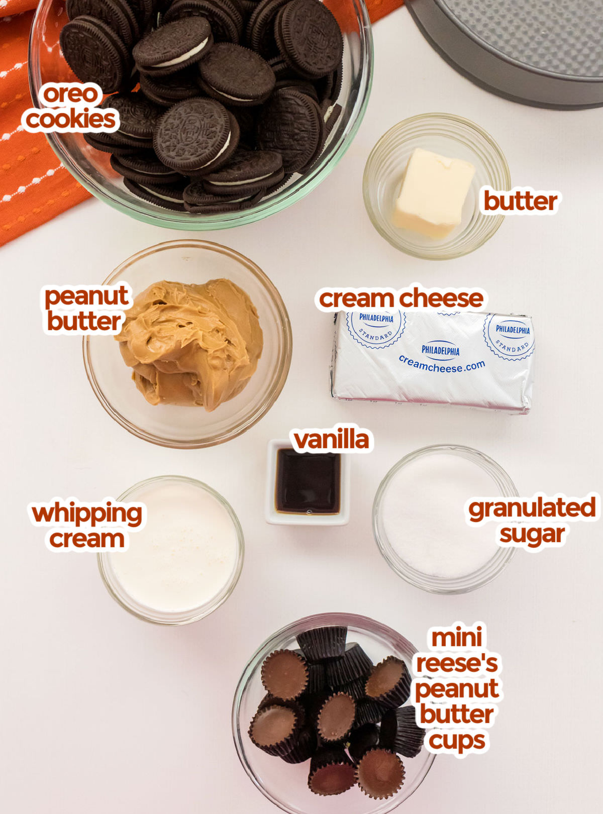 All the ingredients you need to make No Bake Peanut Butter Cheesecake including Oreos, butter, peanut Butter, cream cheese, granulated sugar, vanilla, whipping cream and mini Reese's Peanut Butter Cups.