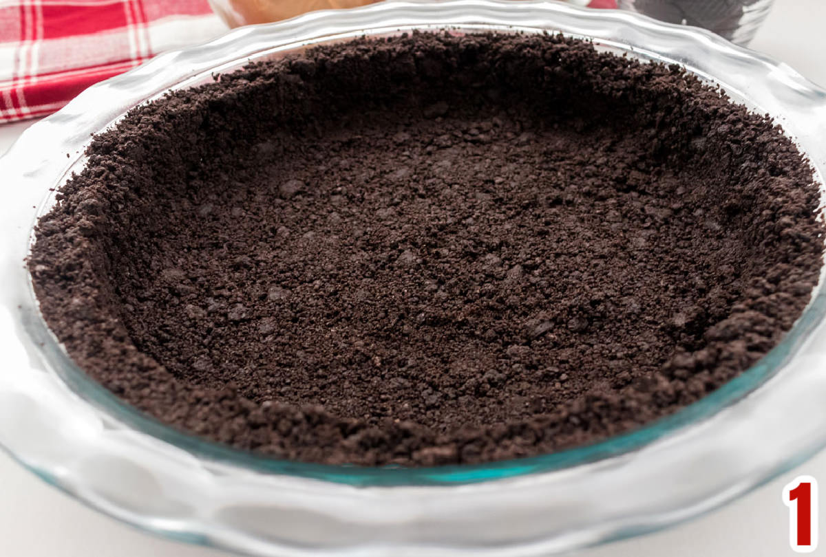 Closeup on an Oreo Cookie crust in an 9" clear glass pie plate.